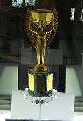 Golden trophy in a presentation case. It depicts the Greek goddess Nike standing with arms aloft.