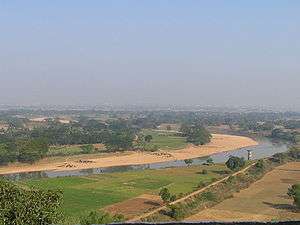 A river passing along green fields