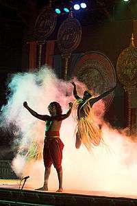 Bare-chested man on stage, surrounded by smoke