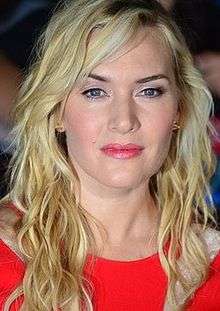 Kate Winslet facing the camera with blonde hair and a red dress on