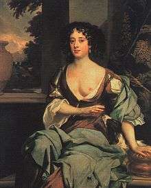 The picture centres on an attractive woman in her late twenties, dressed in long flowing robes suggesting a rural idyll, with one breast exposed towards the viewer. She has dark hair, and a wistful expression.