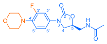 Skeletal formula of N-{[(5S)-3-[3-fluoro-4-(morpholin-4-yl)phenyl]-2-oxo-1,3-oxazolidin-5-yl]methyl}acetamide, highlighting the morpholino and fluoro groups in orange, with the rest in blue. The carbon atoms of the parent chain are numbered.