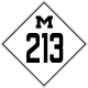 A road sign bearing a diamond enclosing a block M and the number 213