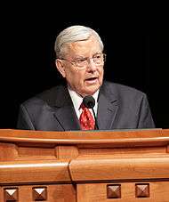 Photo of M. Russell Ballard standing behind a podium and speaking.