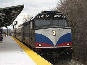 Locomotive pulling older passenger train into station