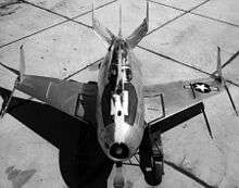 Black-and-white top view of egg-shaped aircraft, with a hook extended over top of canopy