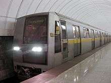 Modern, silver-colored train pulling into a station