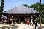 Small wooden building with a trapezoidal roof.