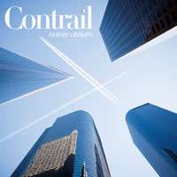 Buildings with airplane contrails against a blue sky.