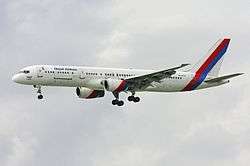 Side view of airliner in flight, with extended landing gear.