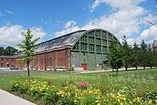 The rear of the armory, with a green wall and many windows in the upper section