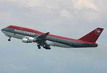 Side view of four-engine jet climbing in the sky.