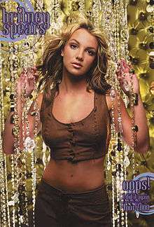 Image of a blond woman. She is wearing a brown top and brown pants. Her hair seems to be moving. The woman is looking directly into the camera. Her hands are against curtains of transparent jewels. The background is composed of dark yellow figures. In the upper left above the woman, the words 'BRITNEY SPEARS' are written in grey and violet handwriting with circles around. In the lower right of the image, the words "OOPS! I DID IT AGAIN TOUR 2000" are written in similar style.