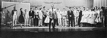 Cast of the show lined up against the back of the stage with Red Foley center-stage