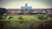 Long, two-story building with towerpunjab group of colleges