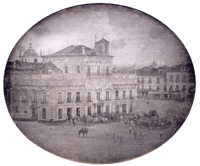 Photograph showing the Imperial Palace in Rio de Janeiro with carriages and mounted honor guard in the square fronting the palace.