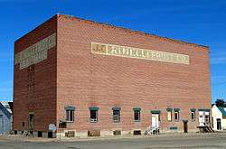 Photograph of the J. C. Palumbo Fruit Company Packing and Warehouse Building, a large, brick, blocky, mostly windowless building