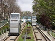 A photograph looking up the railway, showing the two tracks receding into the distance and two cabins, one nearer than the other