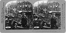 Two identical photos of a man looking out over a large crowd. The images are mounted side-by-side on a card.