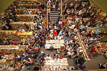 There are many people in a close proximity in a bookstore buying "Harry Potter and the Deathly Hallows".