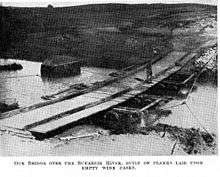 The bridge was constructed by the New Zealand Mounted Rifles Brigade. Long planks of wood were laid across the stream on empty wine casks; shorter planks were then laid on top crosswise to form a flat surface.