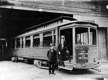 New Orleans Public Service's Prytania streetcar line, 1907. Two uniformed men stand by entrance, presumably the motorman and the conductor. Streetcar is at Arabella Station carbarn.