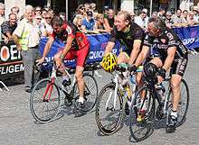 Three men riding bicycles