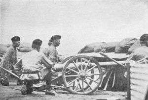 Three artillery men crouch behind a small 2.5 inch "Screw Gun" employed in the defence of Kimberley