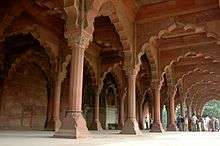 Ornate sandstone pillars and arches, dwarfing tourists