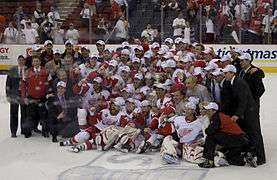 The Detroit Red Wings team, coaches, and support staff pose on the ice with the Stanley Cup.