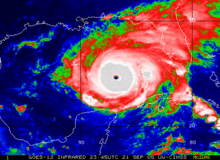 Colorized satellite image of a tropical cyclone. While bluer colors indicate areas of warmer cloud tops, indicative of marginal convective activity, redder and whiter colors indicate areas of colder cloud tops, indicative of stronger convective activity.