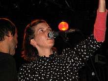 Thomas staring at the ceiling while singing into a microphone