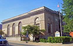 View of side and front of post office, with sign for New York State Route 9N in front