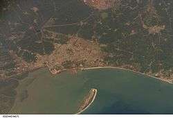 Aerial view of water, a curved shore and a sandspit