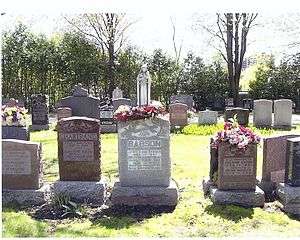 Cemetery headstone among others, with flowers