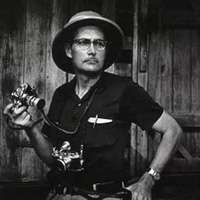 Portrait of W. Eugene Smith holding a camera