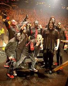 Several members of Slipknot performing on stage, spotlit