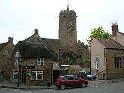 Street scene showing houses with octagonal church tower behind