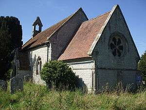 A stone church seen from the south east with steep tiled roofs. Nearest is the chancel with a round east window, beyond that is a larger, higher nave, at the end of which is a bellcote