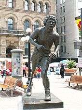 Statue of a runner with an artificial leg partially hunched forward.