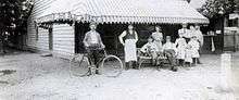 Photo of some men in 19th century garb in front of a bar