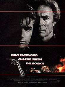 A black poster with three horizontal red lines. Above are the faces of two serious-looking men. The man on the left, is young and black-haired. The man on the right, is older and lighter-haired. The right sides of their faces are invisible because of darkness. Below that in bold white letters are the lines: "The Rookie", "Clint Eastwood" and "Charlie Sheen". To the left of this text is a closeup of a revolver, and to the right and below are police cars, an aircraft, and a fiery explosion. The film credits appear at the bottom, with a line in bold white letters that reads: "Starts Friday December 7 Everywhere".