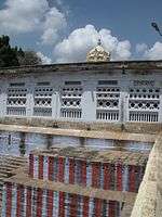 the temple tank with stepped sides, with a shrine in the background