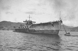 A large ship anchored and at rest near a shoreline.