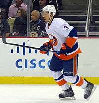 Travis Hamonic skating with his hockey stick.