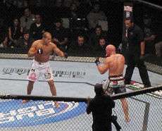 Junior dos Santos, in white shorts, and Shane Carwin, in black shorts, during an MMA match at the main event of UFC 131 in Vancouver, British Columbia, on June 11, 2011.