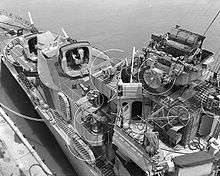 Overhead closeup of the ship's forward superstructure, which bristles with guns, radar arrays, and other equipment