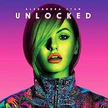 Alexandra Stan is shown sporting a multi-coloured jacket while a neon light reflects on her.