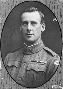 A head and shoulders portrait of a man in military uniform. He has neat, tidy hair and a group of three medal ribbons on his breast. The actual photograph is in the shape of an oval, surrounded by a border.