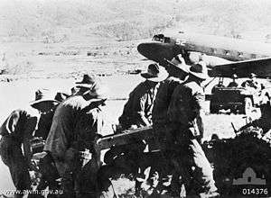 Soldiers in slouch hats manhandle an artillery piece from a plane